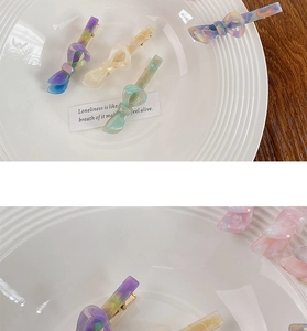 Dettaglio di quattro fermagli a fiocco in acetato marmorizzato in vari colori pastello