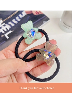 Detail of bear hair ties in green and brown with heart crystal and high elasticity