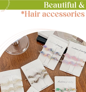 Detail of wavy acetate hair clips in marble patterns on elegant white display cards