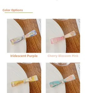 Close-up of handmade acetate bow hair clips with gold foil lettering in various colors