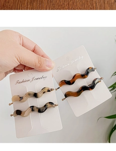 Detail of tortoise shell acetate wavy hair clips with elegant gold metal backing
