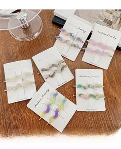 Detail of wavy acetate hair clips in multiple colors on branded display cards