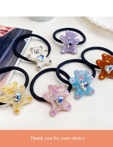 Détail de six chouchous ours colorés avec strass en cœur présentés sur une assiette