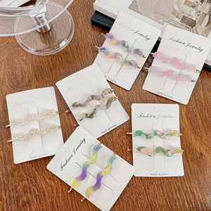 Elegant wave-shaped acetate hair clips with gold label in various marble colors