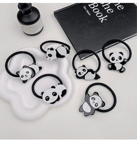 Detailansicht von sechs süßen Panda-Haargummis mit verschiedenen Posen auf einem Tablett