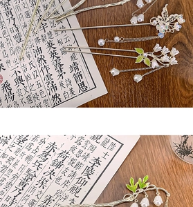Détail d'épingle à cheveux muguet vintage avec papillon argenté et frange à glands
