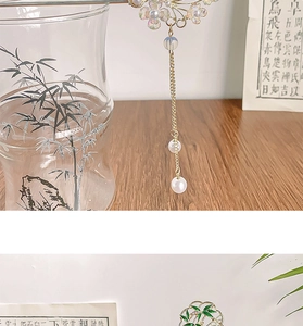 Détail d'épingles à cheveux chinoises avec pétales de fleurs et longs pompons élégants
