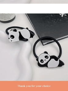 Detailansicht niedlicher Panda-Haargummis mit schwarz-weißen Gummibändern auf Tablett