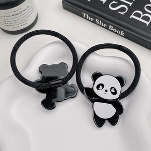 Niedliche Panda-Haargummis in Schwarz und Weiß auf einem minimalistischen Tablett