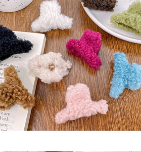 Gros plan de pinces à cheveux en peluche de couleurs variées sur fond en bois