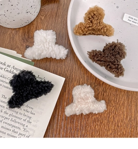 Gros plan de pinces à cheveux en peluche de cinq couleurs sur une table en bois