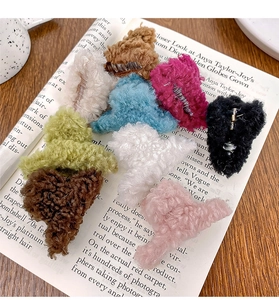 Pince à cheveux en peluche colorée sur magazine, montrant la texture douce et les couleurs