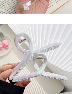 Close-up of infinity shaped iridescent hair claw clip with pearlescent mermaid finish
