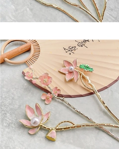 Detailed close-up of golden lotus and cherry blossom hairpins with pearls and enamel