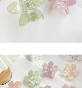 Macro detail of floral acetate hair claw clip with pearlescent finish and metal spring