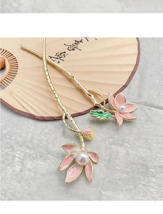 Detailed view of golden lotus hair pins with pink enamel petals and white pearls