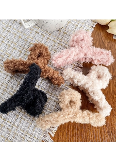 Vue détaillée de cinq pinces à cheveux en peluche douce aux tons pastels et neutres