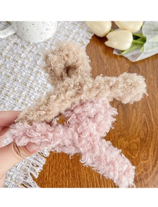 Détail d'une pince à cheveux en polaire bicolore marron et rose avec texture teddy