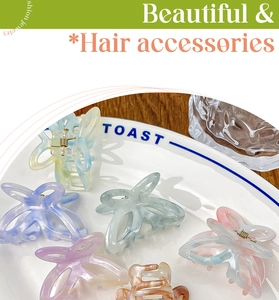 Gros plan de pinces à cheveux papillon en acétate coloré sur une assiette en céramique