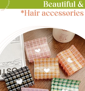 Detail view of assorted checkered hair claws with heart accent on a wooden surface