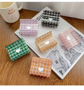 Close-up of heart plaid hair claws in various colors on a stylish lifestyle background