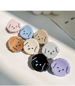 Detailed view of eight colorful cartoon dog acetate hair claws in minimalist white setting