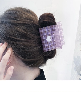 Detail of purple plaid hair claw clip with a white heart accent on a side updo