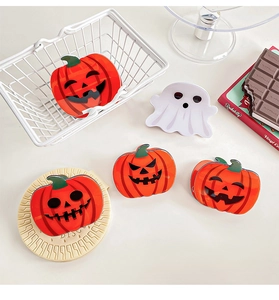 Détail de pinces à cheveux d'Halloween citrouille et fantôme sur support d'exposition blanc