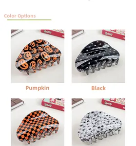 Detail view of large Halloween hair claws featuring pumpkin, skull, and spider patterns