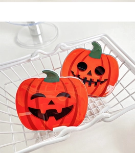 Gros plan de deux pinces à cheveux citrouille d'Halloween avec visages jack-o'-lantern