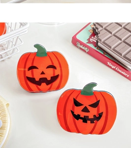 Détail de deux pinces à cheveux citrouille orange pour Halloween avec motifs citrouilles
