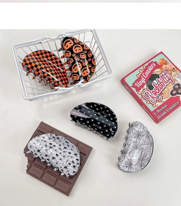 Flat lay of Halloween theme claw clips with pumpkin and spider web patterns