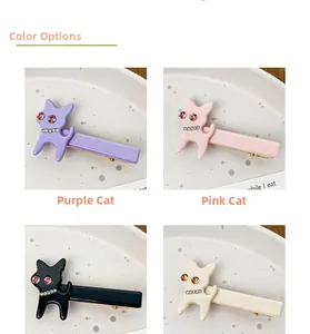 Détail de pinces à cheveux chat en violet, rose, noir et beige avec des strass brillants