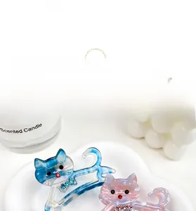 Détail de pinces à cheveux chat en acétate avec strass sur un plateau blanc élégant
