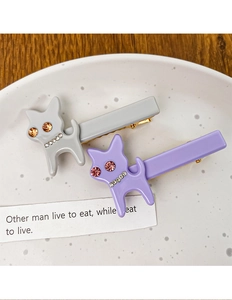 Gros plan sur les barrettes chat en acétate gris et violet avec strass brillants