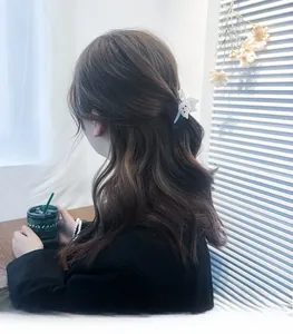 Détail d'une pince à cheveux chat blanche en acétate avec strass sur la coiffure