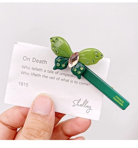 Detail of a handmade green acetate butterfly hair clip featuring sparkling rhinestones