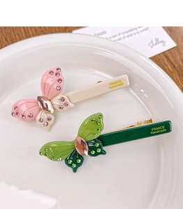 Detailed macro view of acetate butterfly hair clips with crystals and France Handmade logo