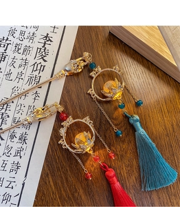 Detail of traditional Chinese hairpins with gold lotus rings and silk tassel pendants