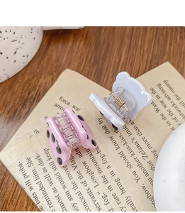 Nahaufnahme der Mini-Panda-Haarklammern in Rosa gepunktet und Weiß auf Vintage-Papier