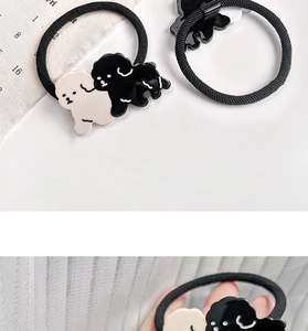 Close-up of cute black and white resin puppy charms on high-elasticity hair ties for kids