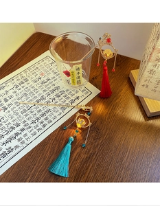Detail of traditional Chinese hairpins with gold metal frames and colorful silk tassels