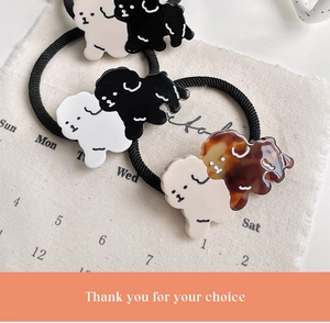 Close-up of cute cartoon dog hair ties in black, white, and tortoiseshell acetate