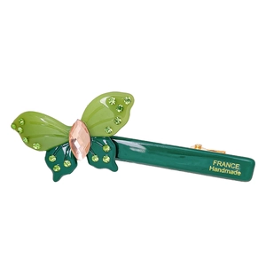 Handmade green butterfly hair clip with crystals and France lettering on a white background