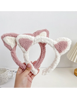 Gros plan détaillé des bandeaux oreilles de chat en peluche rose et blanc dans un décor doux
