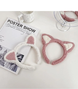 Vue détaillée de bandeaux oreilles de chat en peluche rose et blanc sur table