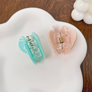 Pinces à cheveux en acrylique en forme de cœur, vert menthe et rose nude sur plateau blanc