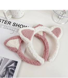 Gros plan détaillé des bandeaux oreilles de chat en peluche rose et blanc sur bureau