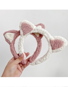 Détail de bandeaux oreilles de chat en peluche rose et blanc avec texture douce en fourrure