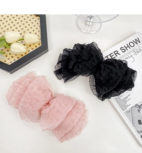 Close-up of pink and black seersucker bow hair clips on a decorative tray